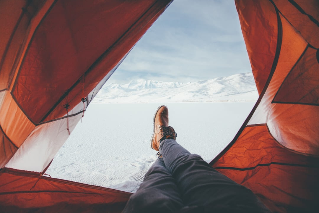 person inside red and white tent on The Frugal Camper