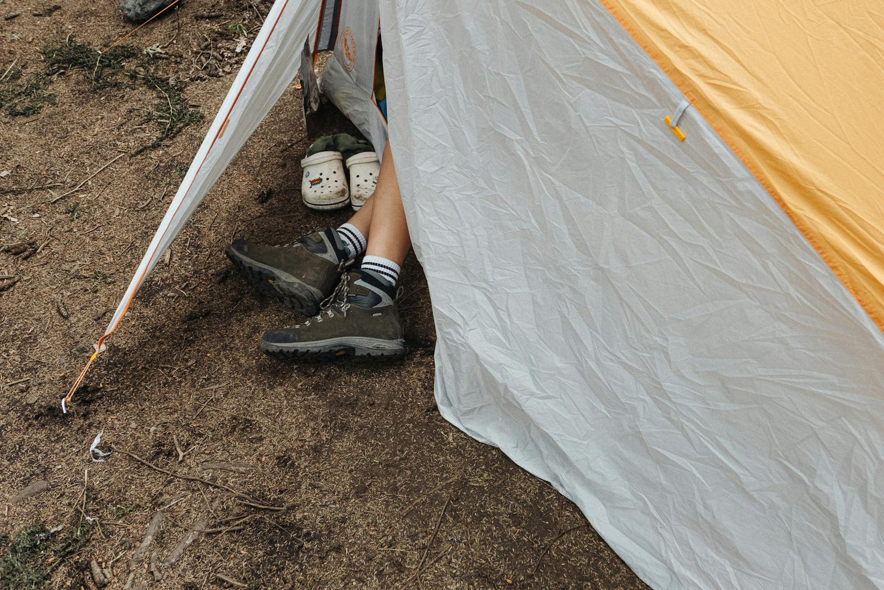 Outdoor camping scene with footwear, tent, and relaxed atmosphere. on The Frugal Camper